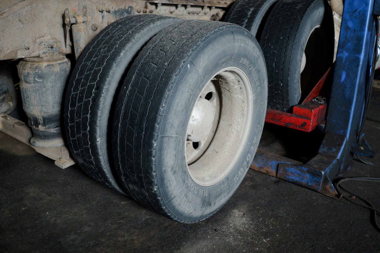 why-choose-us Close-up of truck tires in a garage awaiting maintenance. Industrial setting with a focus on wheels.