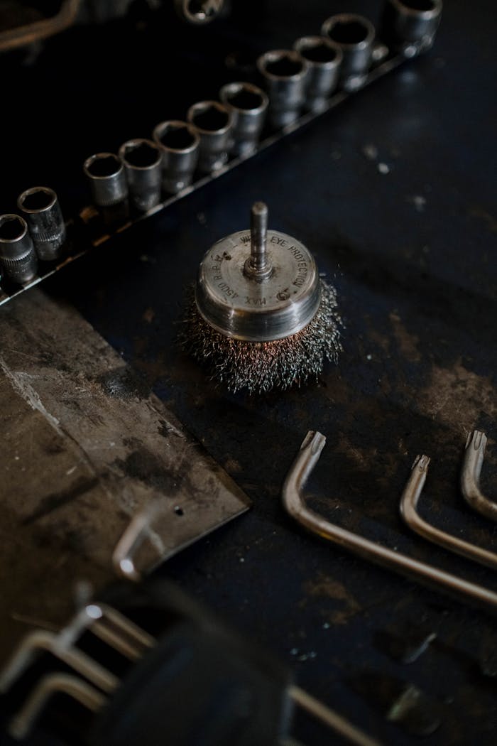 services-04 Close-up of wire brush and assorted tools on a workshop table, ideal for industrial and mechanical themes.