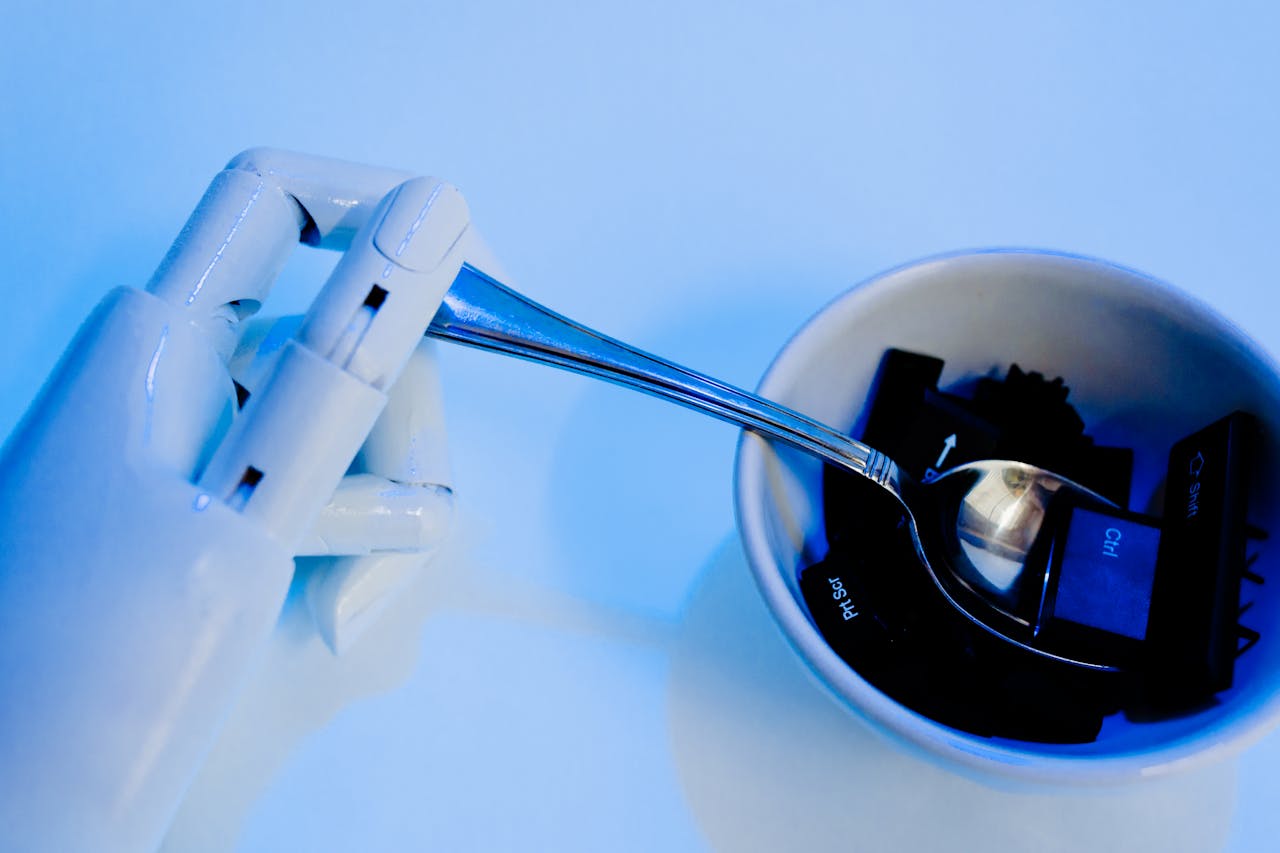 services-02 A robotic hand holding a spoon above a bowl with keyboard keys, showcasing technology themes.